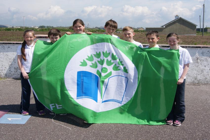 children holding green school flag at glenderry national school